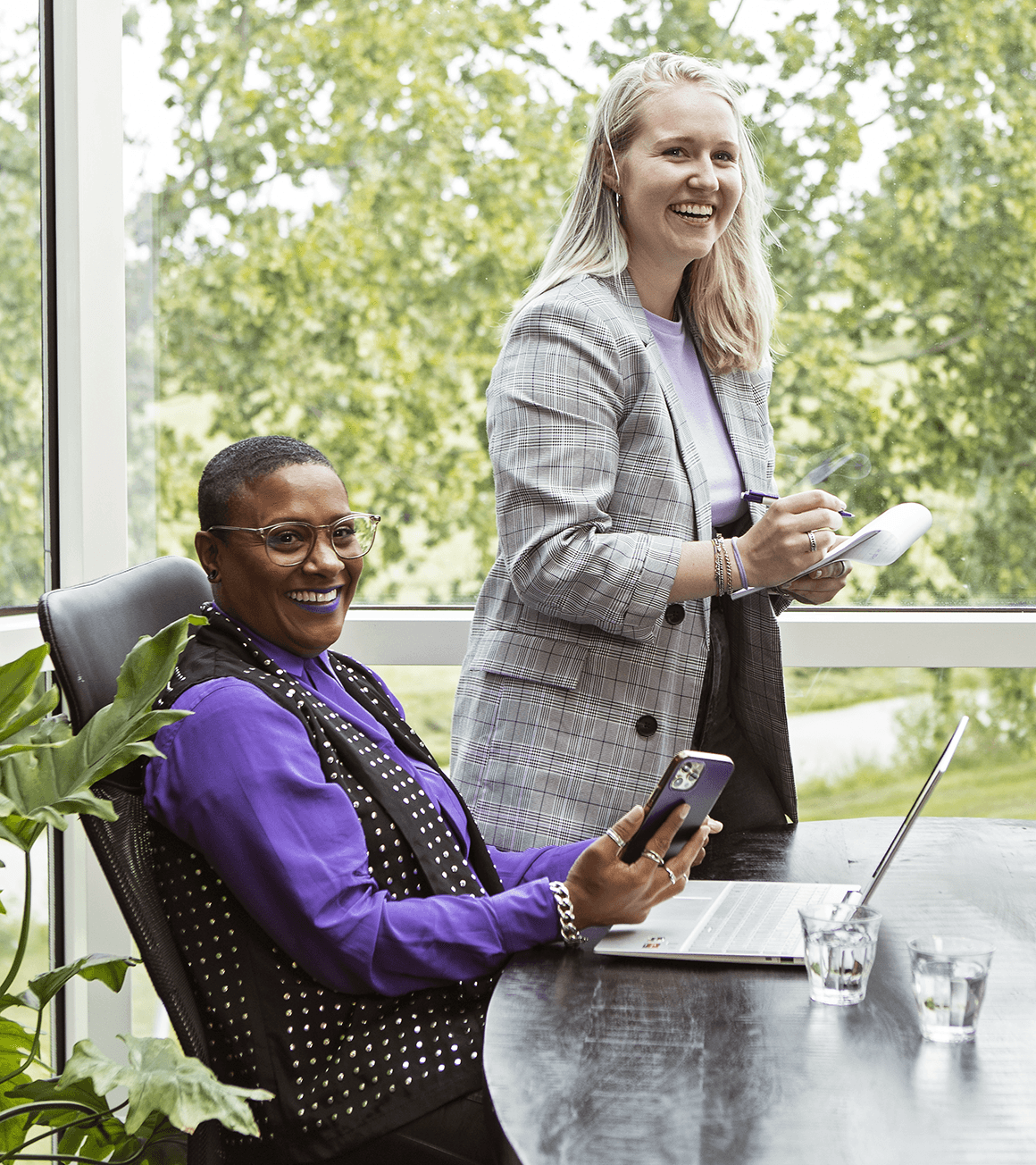Twee collega's aan de vergadertafel bij het raam