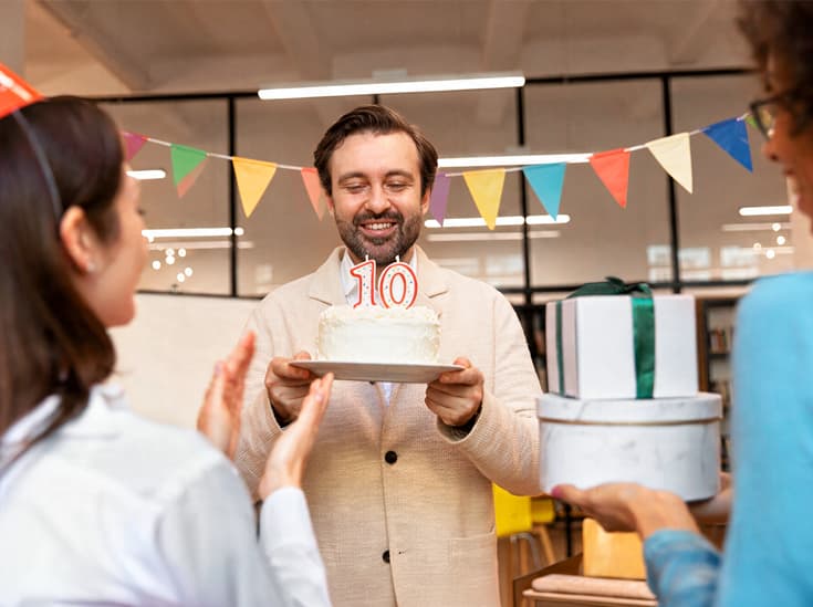 Jubilaris krijgt een gepersonaliseerde cadeaukaart en een taart van collega's