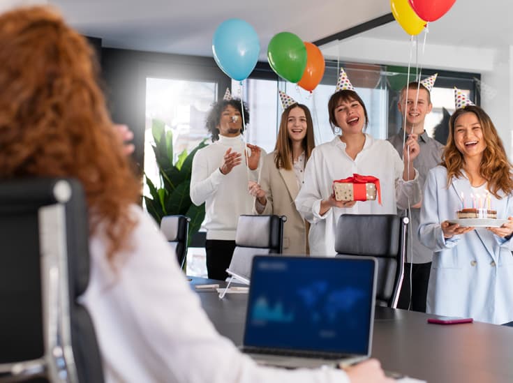 Collega's vieren een verjaardag op kantoor met taart en een cadeaukaart