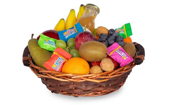 Rieten fruitmand met verse appels, peren, bananen, kiwi, druiven, walnoten, sap en Tony's Chocolonely-reepjes