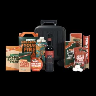 Kerstpakket met zwarte trolley, sportieve snacks en een fles in oranje-zwarte uitvoering
